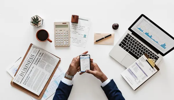 Escriptori d'oficina amb ordinador, calculadora i documents financers